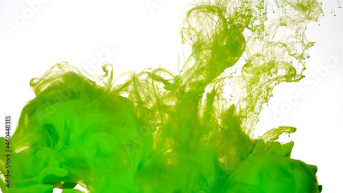 Green paints are mixed in water. Green watercolor ink in water on a white background. Colored cloud of ink on a white background.