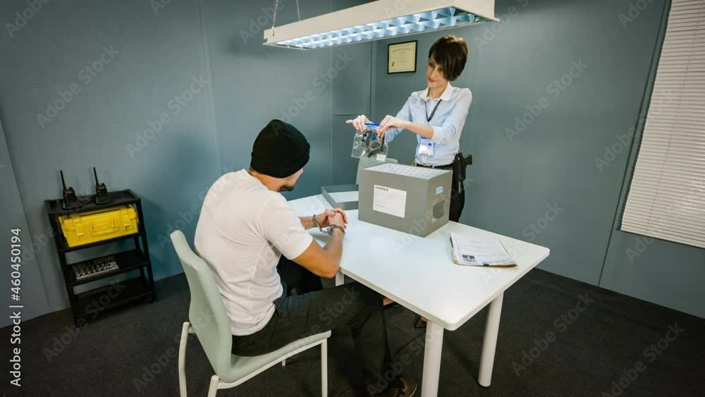 Police woman gets clues from the box and put them in front of the suspect Police woman gets clues from the box and put them in front of the suspect