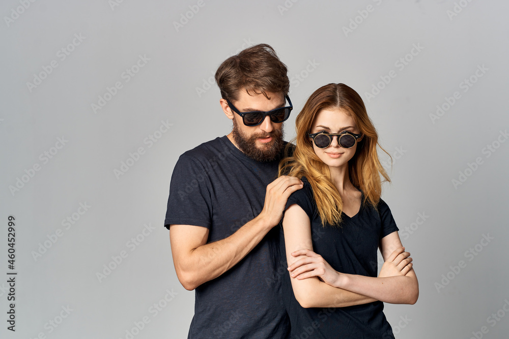 a young couple in black t-shirt sunglasses posing isolated background