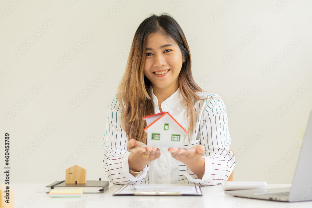 Real estate agents work in offices and clients who are discussing signing contracts for home purchases, insurance, or real estate loans. on the table with laptop and notebook Real estate agents work in offices and clients who are discussing signing contracts for home purchases, insurance, or real estate loans. on the table with laptop and notebook