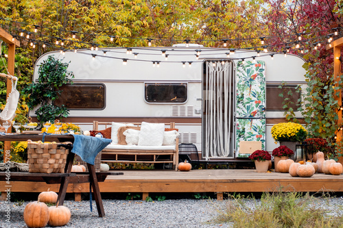 Autumn camping. The trailer is decorated with autumn flower, .pumpkins, decor.