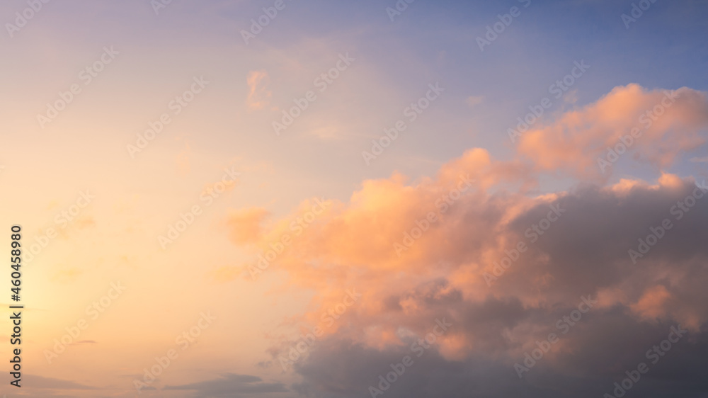 Wonderful view of cumulus clouds sky with orange sun light at sunset of summer