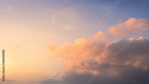 Wonderful view of cumulus clouds sky with orange sun light at sunset of summer