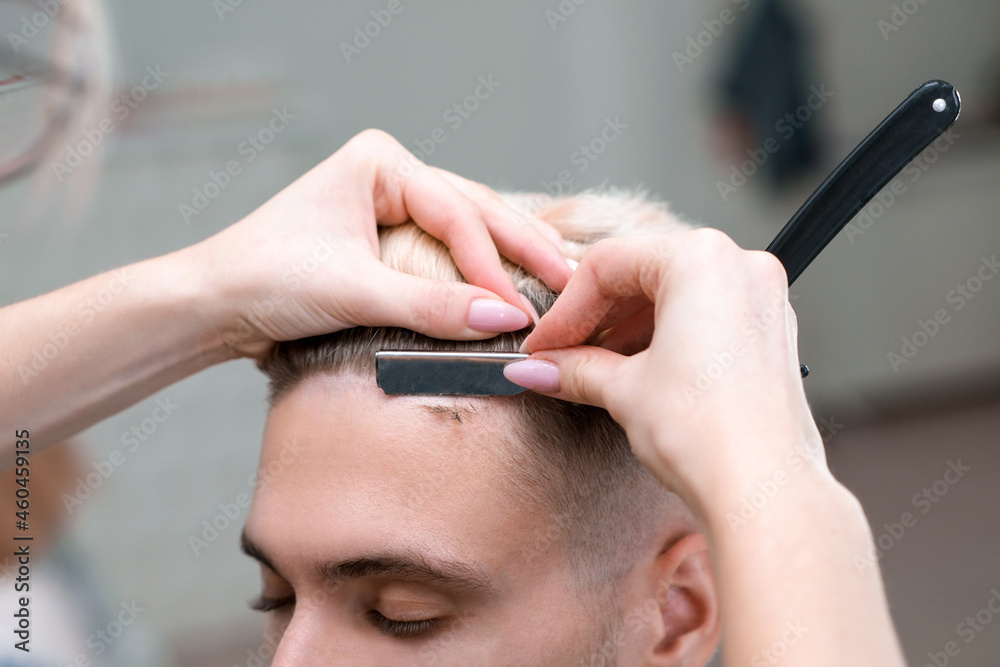 straight razor. haircut process of blond young man in barbershop salon straight razor. haircut process of blond young man in barbershop salon