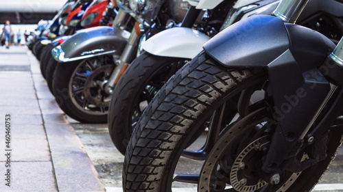 motorcycles parked on the motorcycles parking lot on the street. Closeup view of motorcycles front wheels © Konstantin