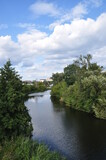 River bend panorama. View of the river with overgrown banks. Beautiful clouds over the river.