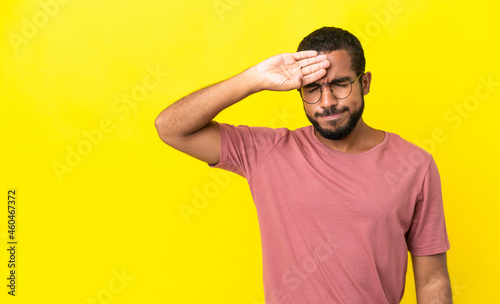 Young latin man isolated on yellow background with tired and sick expression