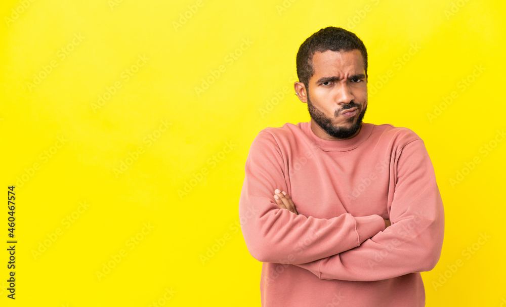 Young latin man isolated on yellow background with unhappy expression Young latin man isolated on yellow background with unhappy expression