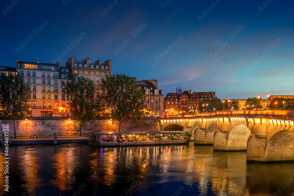 Paris, France - July 8, 2021: Pont Neuf bridge and Cite island over Seine river at night in Paris