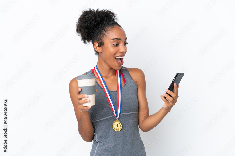 Young African American woman with medals isolated on white background holding coffee to take away and a mobile