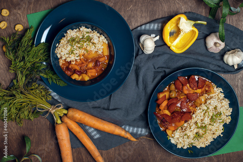 Pilaf bowl (plov, pilaw, pilau) on dark blue bowls decorated with ingridents. Traditional middle east cuisine. Uzbekistan dish made of rice, beef , spices, carrot, onion and garlic. photo