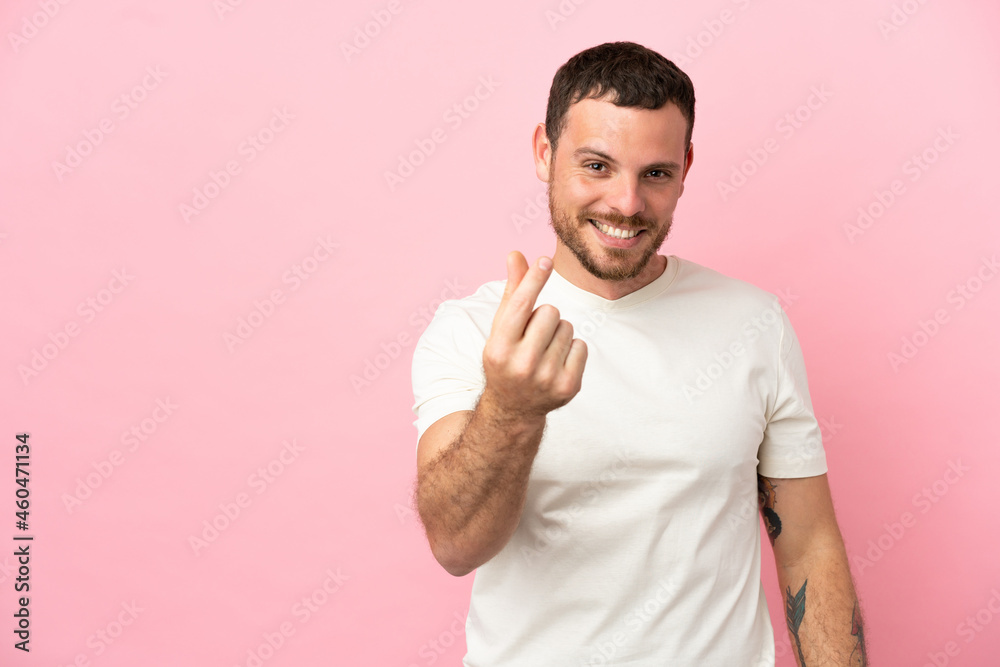 Young Brazilian man isolated on pink background making money gesture Young Brazilian man isolated on pink background making money gesture