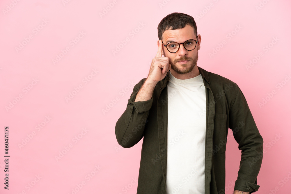 Young Brazilian man isolated on pink background thinking an idea Young Brazilian man isolated on pink background thinking an idea