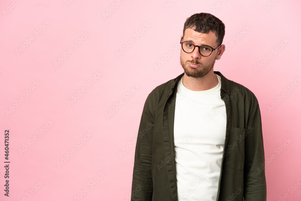 Fototapeta premium Young Brazilian man isolated on pink background with sad expression