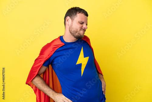 Super Hero Brazilian man isolated on yellow background suffering from backache for having made an effort