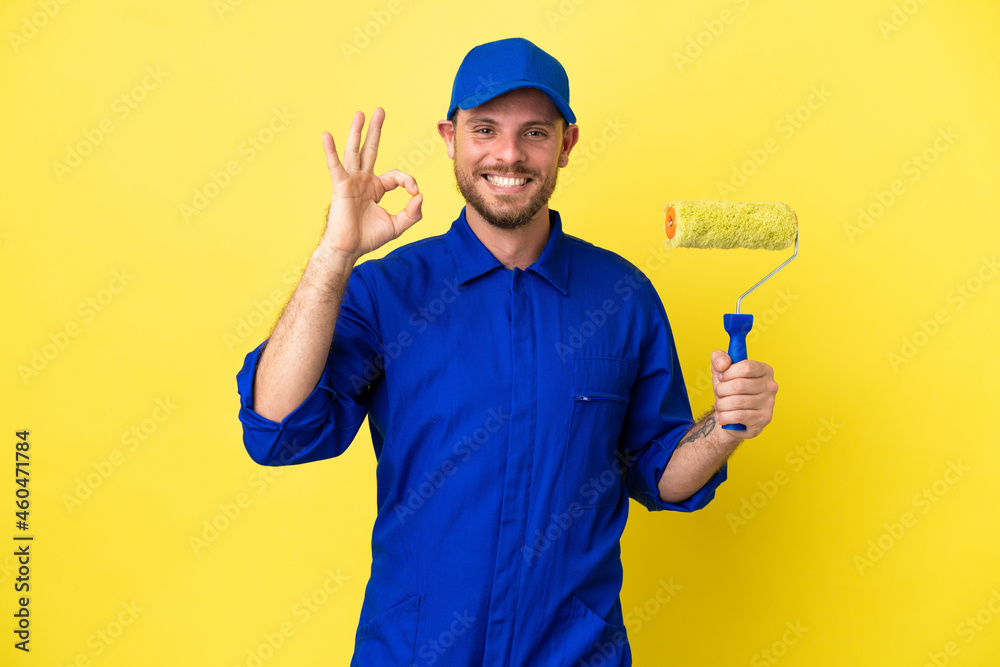 Painter Brazilian man isolated on yellow background showing ok sign with fingers