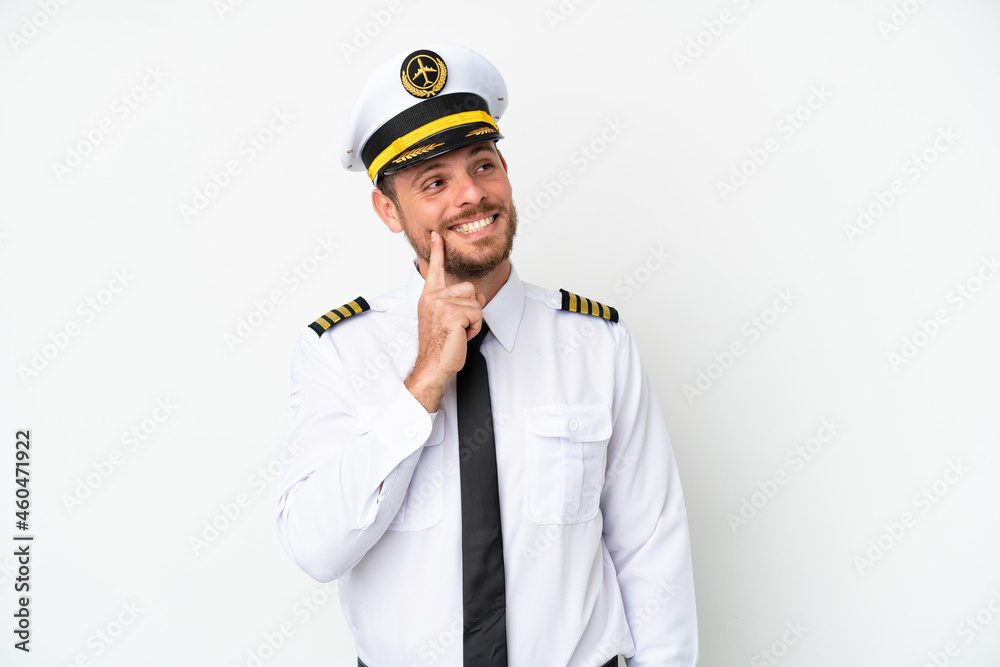 Airplane Brazilian pilot isolated on white background thinking an idea while looking up Airplane Brazilian pilot isolated on white background thinking an idea while looking up
