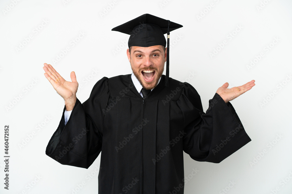 Young university Brazilian graduate isolated on white background with shocked facial expression Young university Brazilian graduate isolated on white background with shocked facial expression