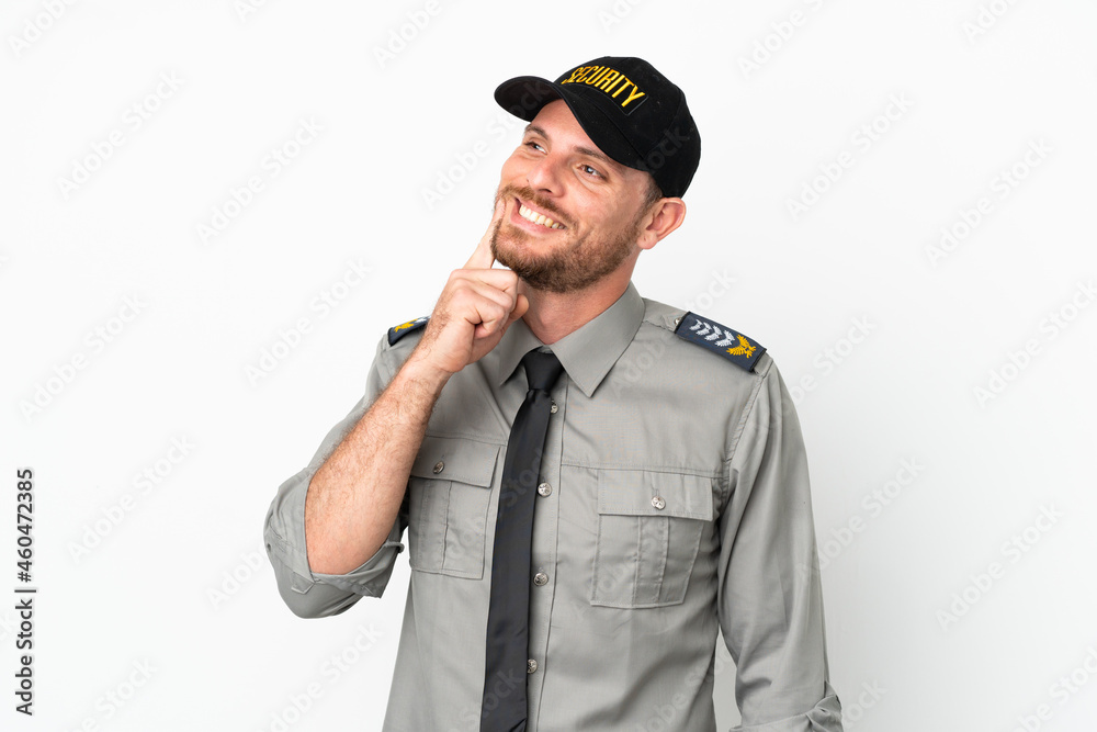 Young security Brazilian man isolated on white background thinking an idea while looking up Young security Brazilian man isolated on white background thinking an idea while looking up