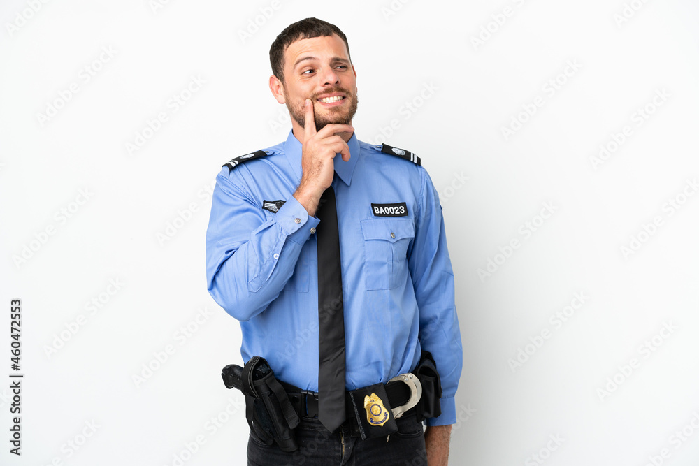 Young police Brazilian man isolated on white background thinking an idea while looking up Young police Brazilian man isolated on white background thinking an idea while looking up