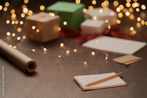 White paper notepad with pencil on wood table with christmas decorations