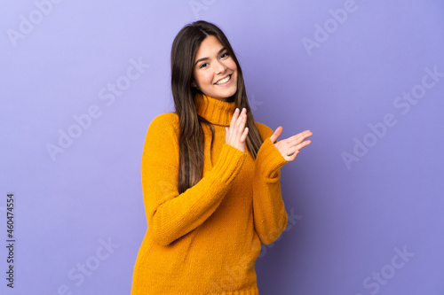Teenager Brazilian girl over isolated purple background applauding © luismolinero