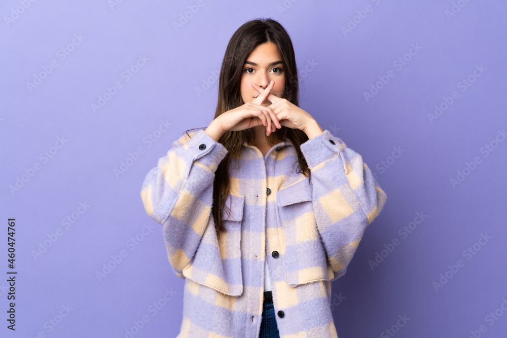 Teenager Brazilian girl over isolated purple background showing a sign of silence gesture Teenager Brazilian girl over isolated purple background showing a sign of silence gesture
