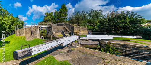 A panorama view across lock gates on the Five Locks network on the Leeds, Liverpool canal at Bingley, Yorkshire, UK in summertime photo