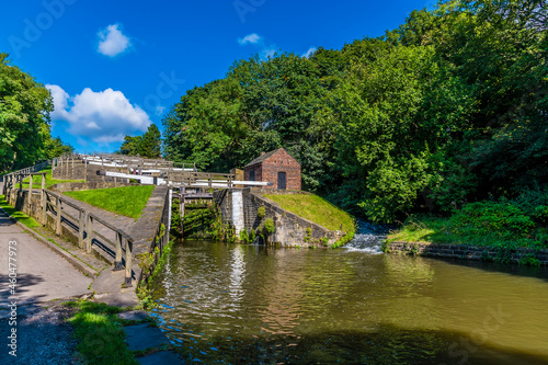 A view on the canal bank looking up the Five Locks network on the Leeds, Liverpool canal at Bingley, Yorkshire, UK in summertime photo