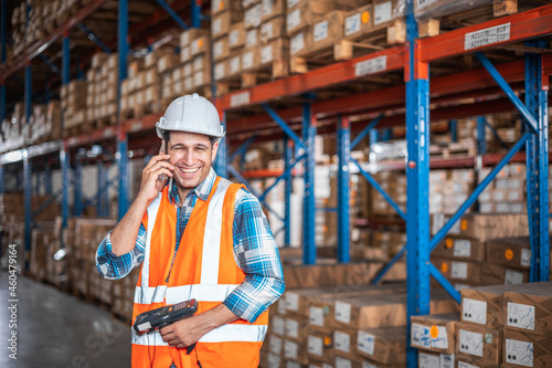 Portrait of confident worker using telephone in distribution warehouse