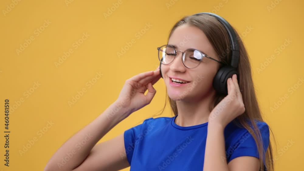 Closeup happy face young blonde female dj in headphones dancing singing song enjoying audio sound Closeup happy face young blonde female dj in headphones dancing singing song enjoying audio sound
