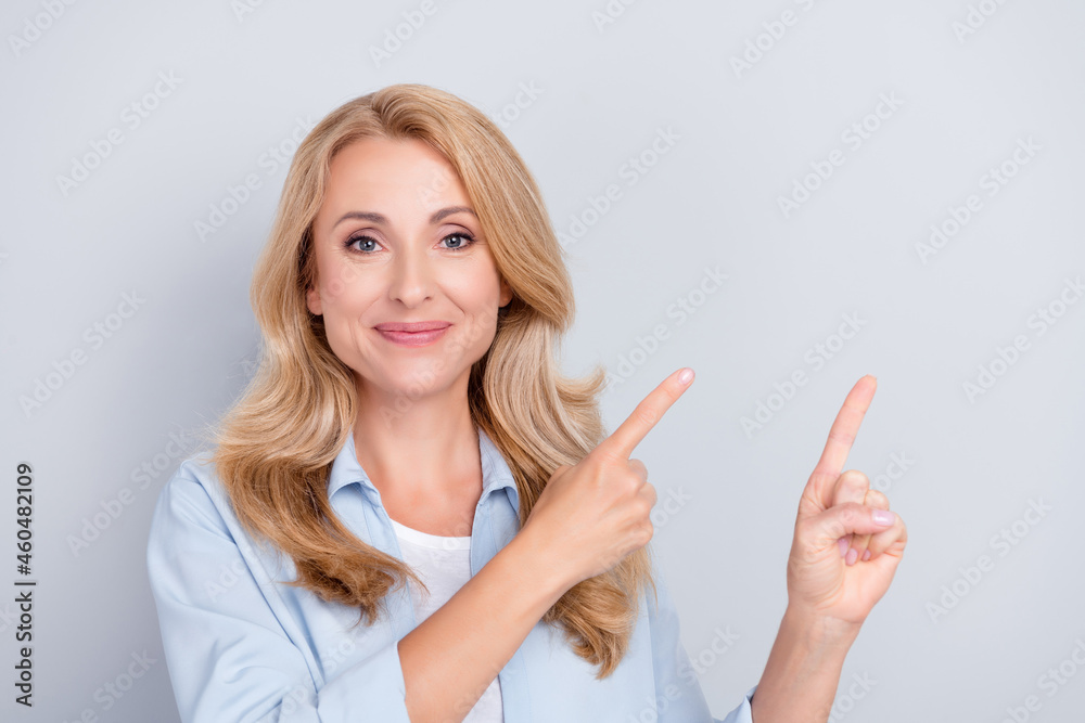Photo of adviser worker lady indicate forefinger empty space wear blue shirt isolated grey color background Photo of adviser worker lady indicate forefinger empty space wear blue shirt isolated grey color background