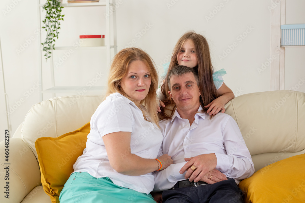 Family sitting on sofa in their living room. Daughter have injury hand but she is happy be together her family.