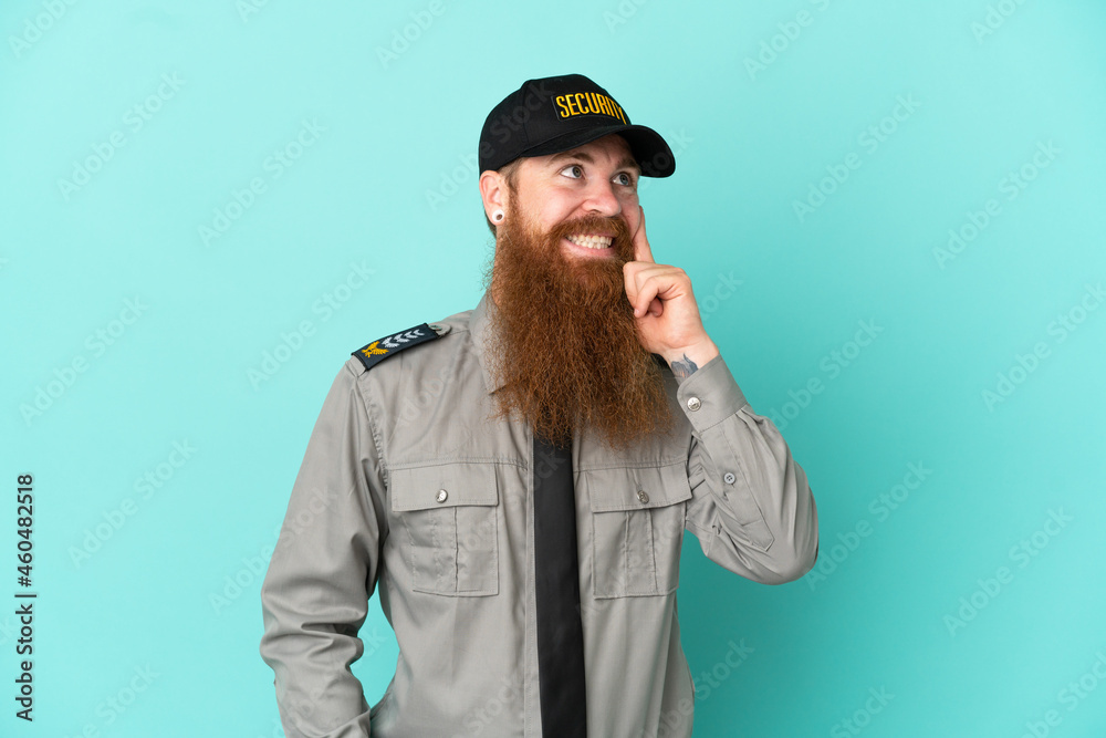 Redhead security man isolated on white background thinking an idea while looking up Redhead security man isolated on white background thinking an idea while looking up