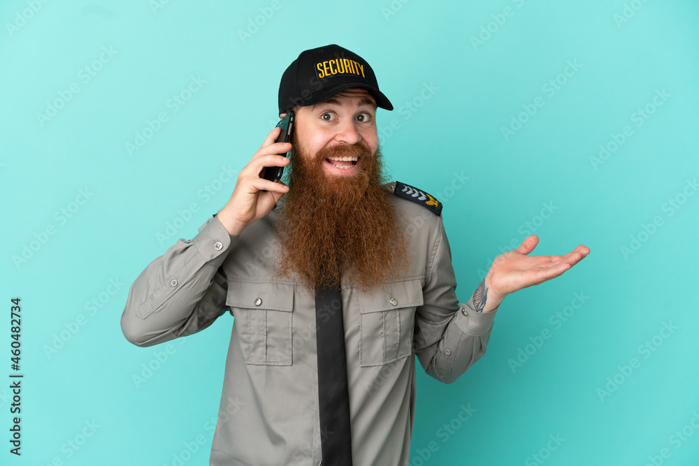 Redhead security man isolated on white background keeping a conversation with the mobile phone with someone Redhead security man isolated on white background keeping a conversation with the mobile phone with someone