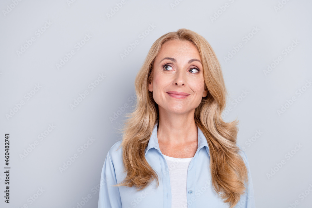 Portrait of young smiling beautiful female with blonde hair look copyspace thinking isolated on grey color background Portrait of young smiling beautiful female with blonde hair look copyspace thinking isolated on grey color background