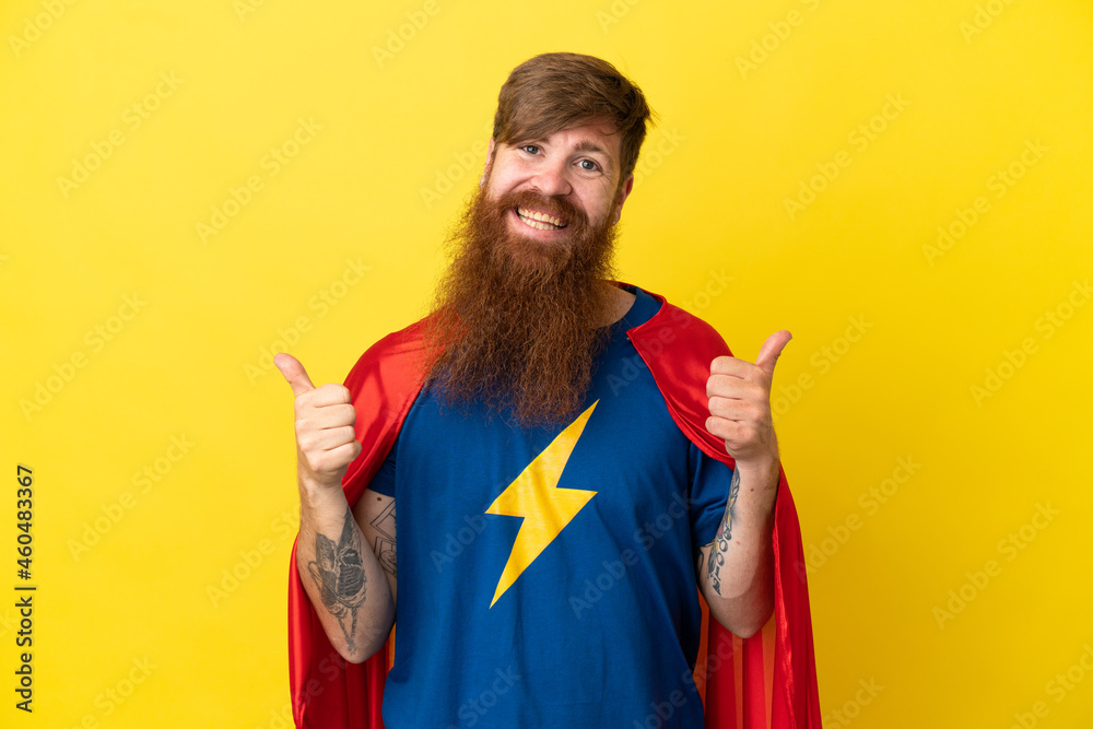 Redhead Super Hero man isolated on yellow background with thumbs up gesture and smiling Redhead Super Hero man isolated on yellow background with thumbs up gesture and smiling