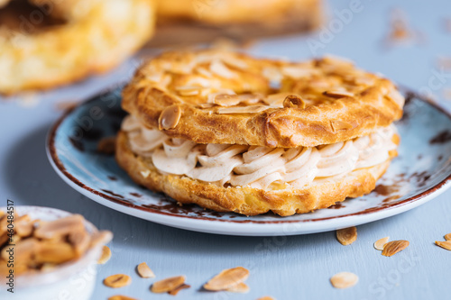 Canvas Print Dessert called Paris Brest on a grey background with powder sugar and almond lea
