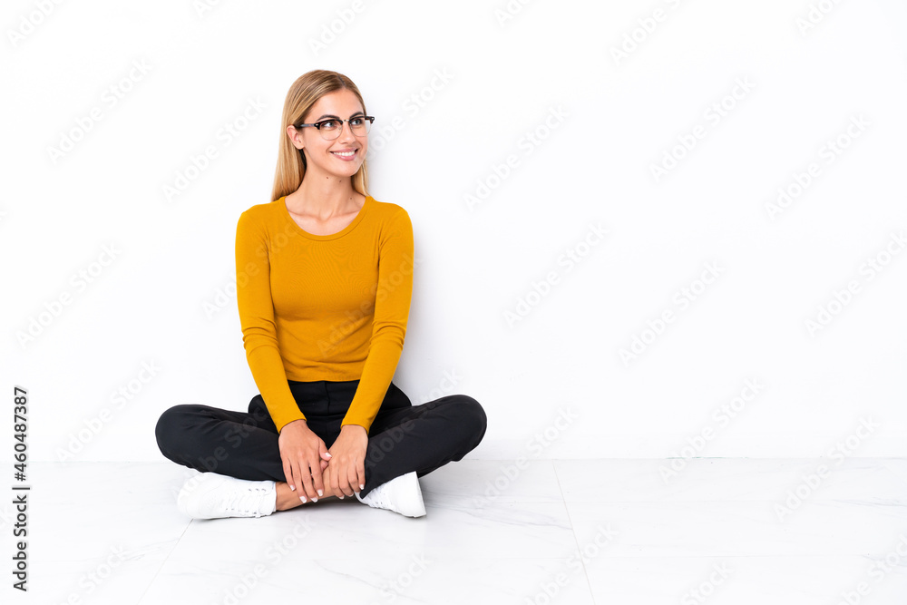 Fototapeta premium Blonde Uruguayan girl sitting on the floor looking side