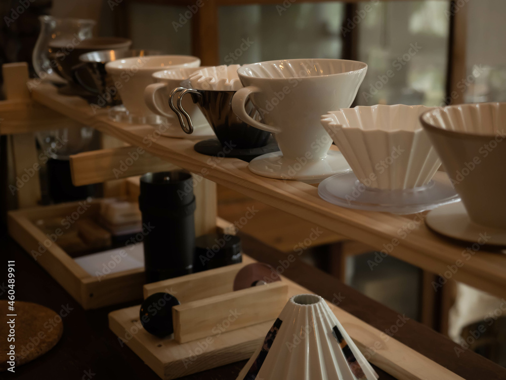 The dripper many kind on shelf in the bottom have manual coffee grinder black color focus on the dripper The dripper many kind on shelf in the bottom have manual coffee grinder black color focus on the dripper
