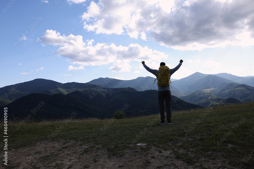 Triumphant tourist on top of mountain, back view. Space for text Triumphant tourist on top of mountain, back view. Space for text