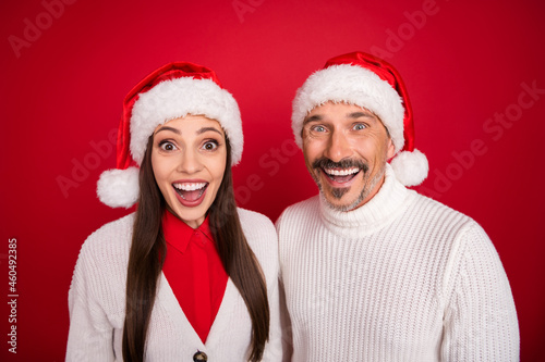 Photo of happy positive mature man and woman amazed excited mood christmas isolated on red color background