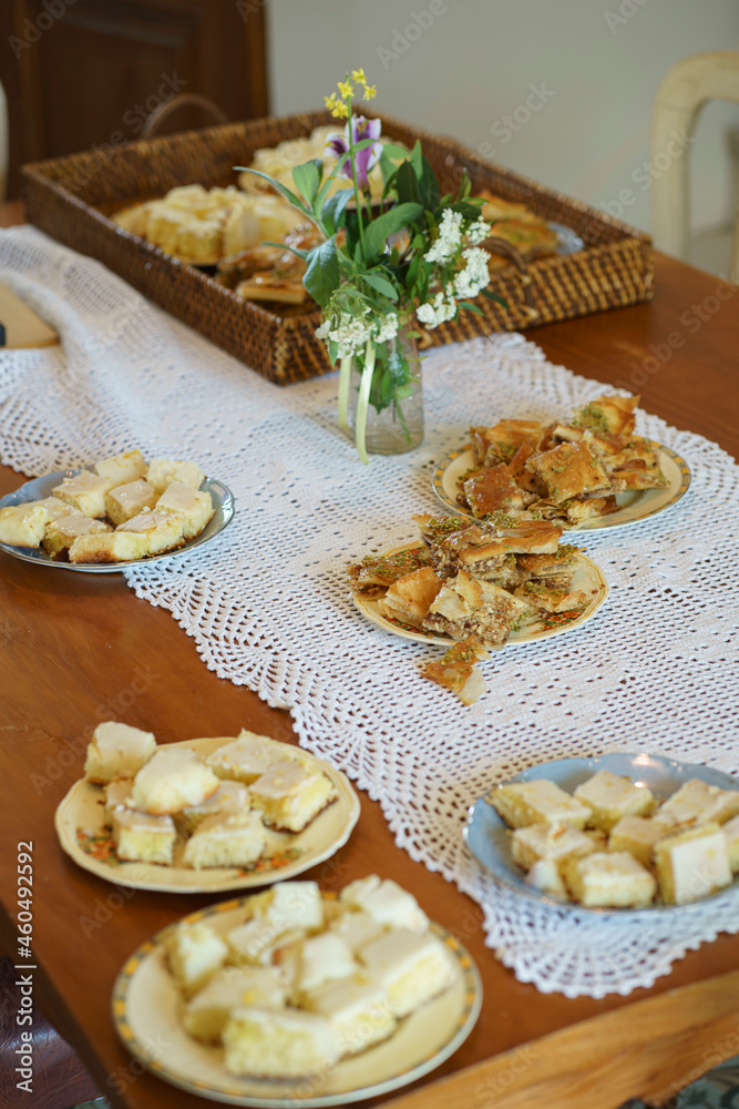 table decorated with tablecloth vase and sweet plates with focus on one with turkish dessert baklava