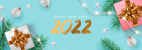 Happy New Year 2022 greeting card, banner or poster design template with realistic gift boxes, pine tree banches and decorations. photo