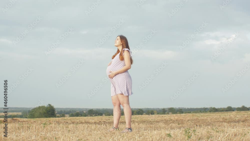 camera rotating around happy young pregnant woman in dress standing alone in field on background of cloudy rainy sky, relaxation on nature camera rotating around happy young pregnant woman in dress standing alone in field on background of cloudy rainy sky, relaxation on nature
