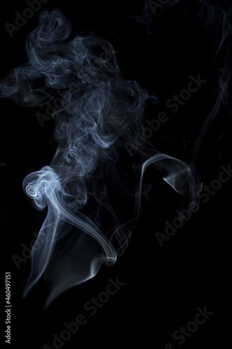The smooth movement of white smoke on a black background, abstract things on a black background. © Teeranan