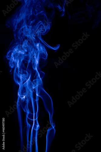 Fototapeta Naklejka Na Ścianę i Meble -  The movement of blue smoke faces a fierce fierce black background on abstract things on a black background.