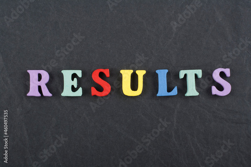 RESULTS word on black board background composed from colorful abc alphabet block wooden letters, copy space for ad text. Learning english concept.