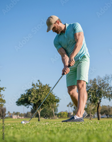 concentrated golfer in cap with golf club, golfing