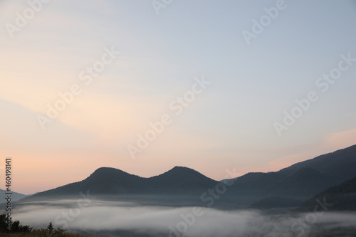 Picturesque view of mountains covered with fog in morning
